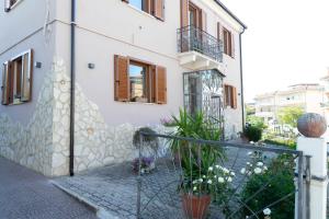 a white building with a fence and plants in front of it at Bed & Breakfast Mafi in Orsogna