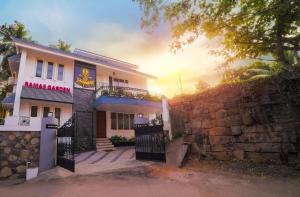 a house with a stone wall and a fence at RAMAS GARDEN in Trivandrum