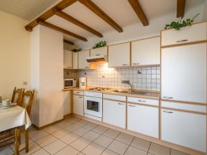 a large kitchen with white cabinets and a table at Apartment with sauna in Eschfeld in Eschfeld
