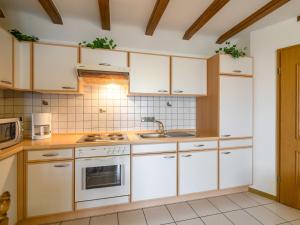 una cocina con armarios blancos y fregadero en Apartment with sauna in Eschfeld, en Eschfeld