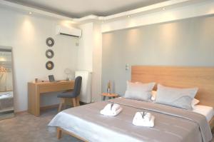 1 dormitorio con 1 cama y 2 toallas blancas en BEAUTIFUL PEOPLE SUITES ATHENS ACROPOLIS VIEW, en Atenas