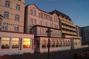 ein Gebäude mit Straßenbeleuchtung davor in der Unterkunft Strandhotel Ostfriesenhof in Borkum