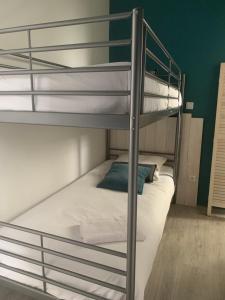 a bunk bed with white sheets and a blue pillow at Le Louisiane in Soorts-Hossegor