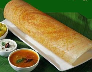 un rollo de pan en un plato con un tazón de sopa en Nestlay Rooms Vanagaram, en Chennai