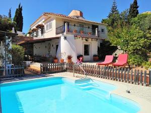 a villa with a swimming pool in front of a house at Moinho do Marco in Setúbal