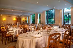 a banquet room with tables and chairs with white tablecloths at Parma E Oriente in Montecatini Terme