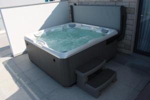 a jacuzzi tub in a bathroom with a stool at Beach Hotel Split in Podstrana