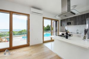 a kitchen with a view of a pool at Villa Lubey in Ljubač