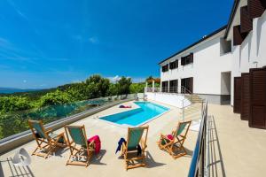 a balcony with chairs and a swimming pool at Villa Lubey in Ljubač