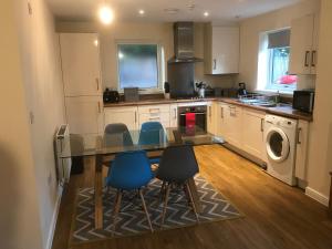 a kitchen with a table and blue chairs in it at Southampton Gem in Southampton