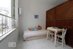 a room with a desk and a table and a window at Andar Alto Frente Ipanema in Rio de Janeiro