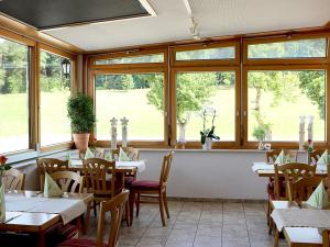 a restaurant with tables and chairs and windows at Landgasthof Waldeck in Dürbheim