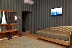 ローマにあるホテル リリコのベッド1台、壁掛けテレビが備わるホテルルームです。