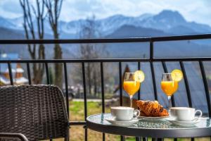 a table with two glasses of orange juice and food at Hotel Tatra in Zakopane