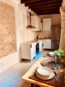 a kitchen with white cabinets and a wooden table at El Apartamento de la Yaya in Toledo +21 photos