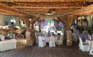 un salón de banquetes con mesas blancas y sillas en un granero en Schloss Diedersdorf, en Diedersdorf