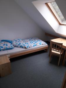 sypialnia z łóżkiem i drewnianym stołem w obiekcie Dworek Cicha Noc w mieście Tarnowo Podgórne
