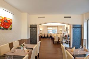 a restaurant with tables and chairs and a bar at Hotel Restaurant Kromberg in Remscheid