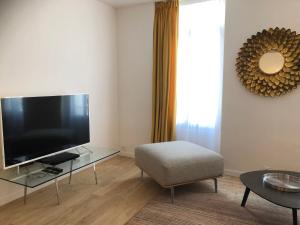 - un salon avec une télévision à écran plat et une chaise dans l'établissement Luxe et Confort - Proche Palais et plages - A/C, à Cannes