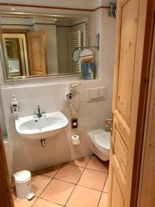 ein Badezimmer mit einem Waschbecken, einem WC und einem Spiegel in der Unterkunft Schloss Diedersdorf in Diedersdorf