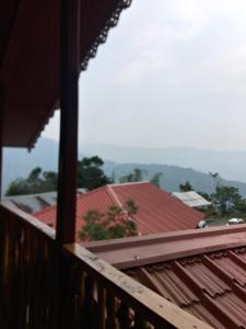 a view from the balcony of a house with red roofs at Yuma Homestay in Mangpu +7 photos