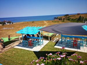 a group of tables and chairs under an umbrella on the beach at Hotel Bavaria in Sinemorets
