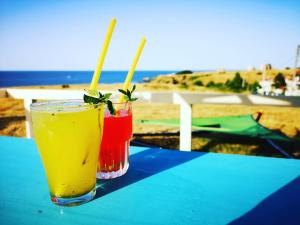 two drinks sitting on a table near the beach at Hotel Bavaria in Sinemorets