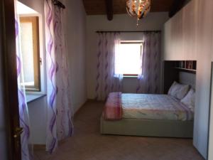 um quarto com uma cama e uma janela em Casa per vacanze in Meana di Susa em Meana di Susa