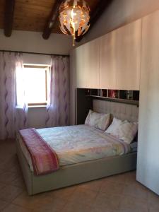 a bedroom with a bed with a window and a chandelier at Casa per vacanze in Meana di Susa in Meana di Susa