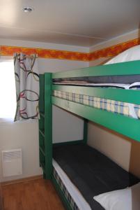 מיטה או מיטות קומותיים בחדר ב-MOBILHOME 3 CHAMBRES