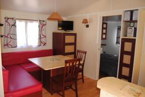 a small living room with a table and a couch at MOBILHOME 3 CHAMBRES in Veyrignac
