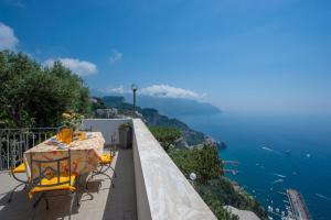 a table and chairs on a balcony overlooking the ocean at Prima Luce in Amalfi