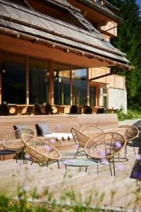 a group of chairs and tables in front of a building at Boutique hotel Vila Planinka in Zgornje Jezersko