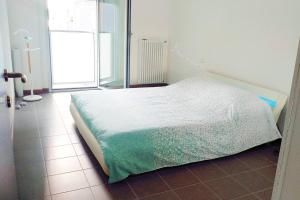 a white bed in a room with a window at Navigli House in Milan