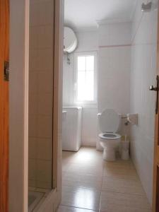 Un baño con inodoro y ventana. en ApartRoquetas, en Roquetas de Mar