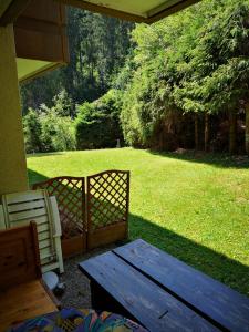 eine Veranda mit einem Holztisch und Stühlen sowie einem Hof in der Unterkunft Appartment Leo in Schönwald