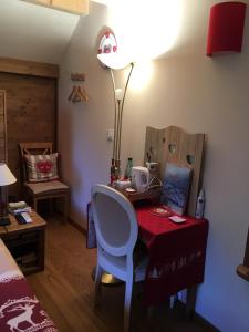 a bedroom with a desk with a chair and a lamp at La Maison des Coeurs in Attignat-Oncin