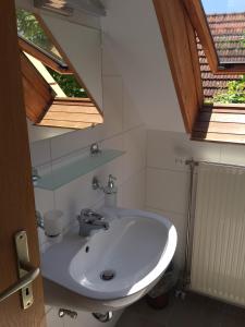 um lavatório branco numa casa de banho com duas clarabóias em Villa Elysium em Gyenesdiás