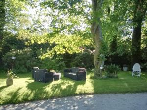 um jardim com uma mesa e cadeiras na relva em Château Bily B&B Hôtel em La Chèze