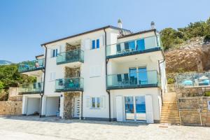 a white house with blue balconies on a hill at 2Bfree in Stinica