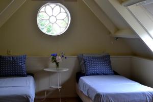 a attic room with two beds and a window at Het Friese Huisje in Boazum