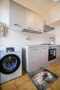 uma cozinha com uma máquina de lavar roupa e um fogão em A casa di Rossella em Catânia