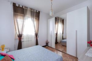 a bedroom with two beds and a mirror at House Henry in Vado Ligure