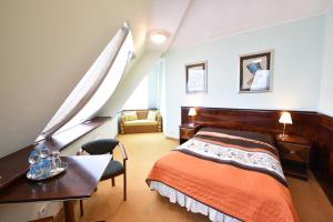 1 dormitorio con cama, escritorio y silla en Piramida Park Hotel & Wellness, en Tychy