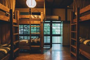 a room with several bunk beds and a chandelier at Guesthouse toco in Tokyo