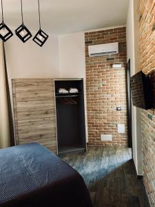 a bedroom with a brick wall and a door at LoFT in Bosa