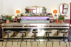 a bar with stools in the middle of a room at Ostello Tasso in Florence