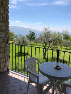 einen Tisch und Stühle auf einem Balkon mit Aussicht in der Unterkunft Garnì Marika in Gargnano
