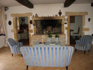 a living room with a table and chairs and a fireplace at Chateau De Martigny in Poisson