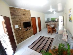 a living room with a wooden accent wall and a couch at Casa Temporada com Ar cond e Wifi in Barreirinhas